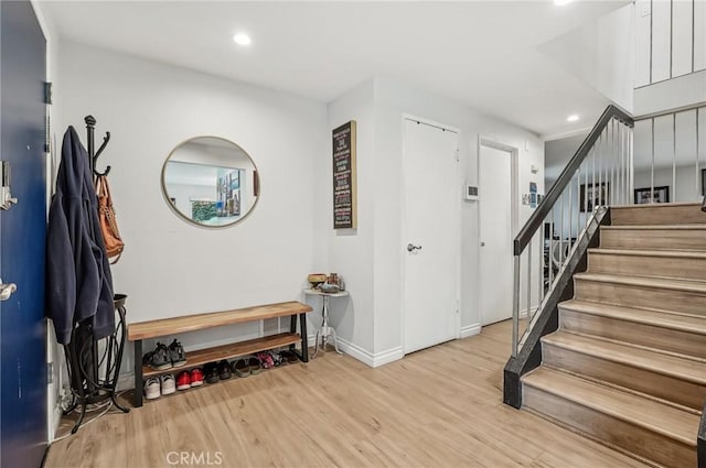 interior space featuring baseboards, stairway, wood finished floors, and recessed lighting