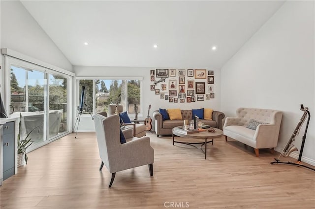 living room with high vaulted ceiling, light wood-style flooring, and recessed lighting