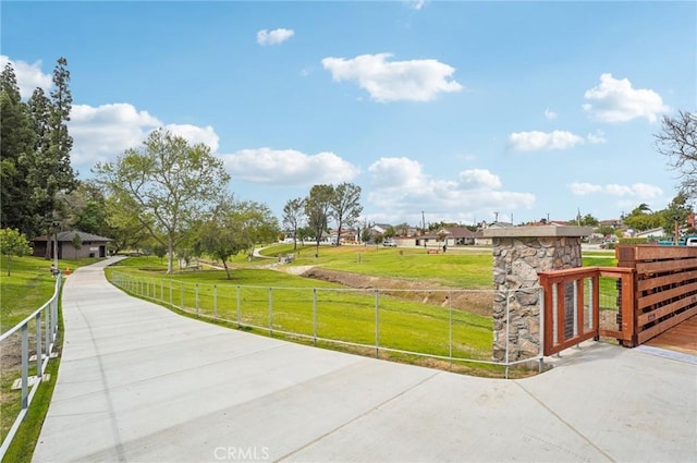 view of community with a lawn and fence