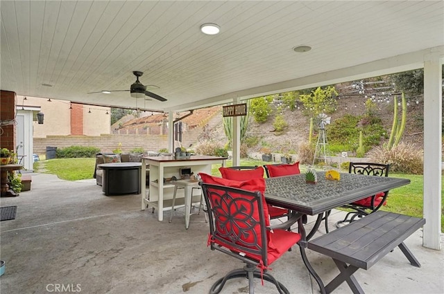 view of patio / terrace with outdoor dry bar, outdoor dining space, and a ceiling fan