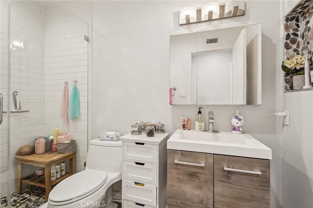 bathroom featuring toilet, a shower stall, visible vents, and vanity