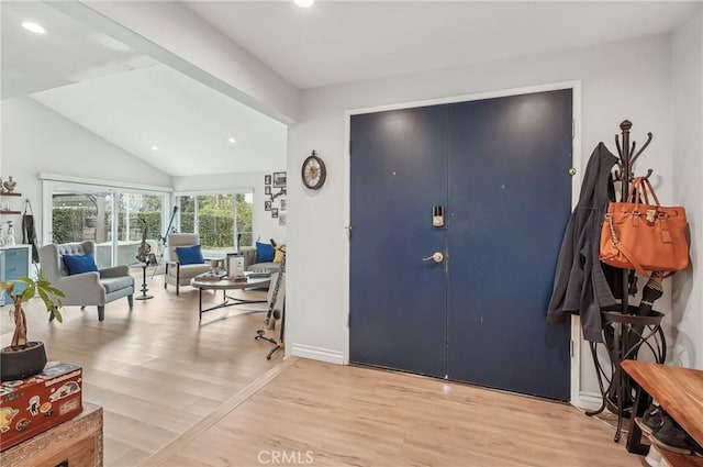 foyer entrance with light wood finished floors, vaulted ceiling, and recessed lighting