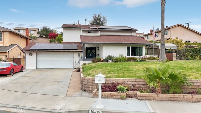 traditional-style home featuring concrete driveway, an attached garage, roof mounted solar panels, fence, and a front lawn