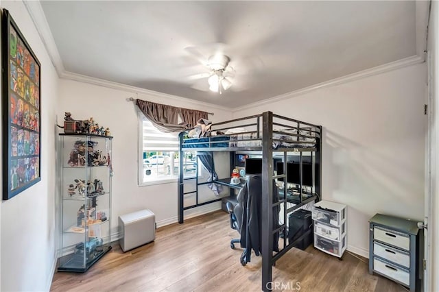 bedroom with ornamental molding, a ceiling fan, baseboards, and wood finished floors
