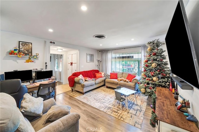 living room with light wood-style floors, visible vents, and recessed lighting
