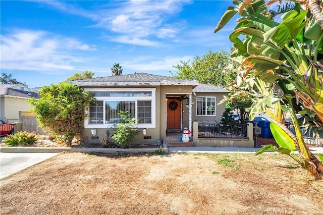 view of front of property with fence and stucco siding