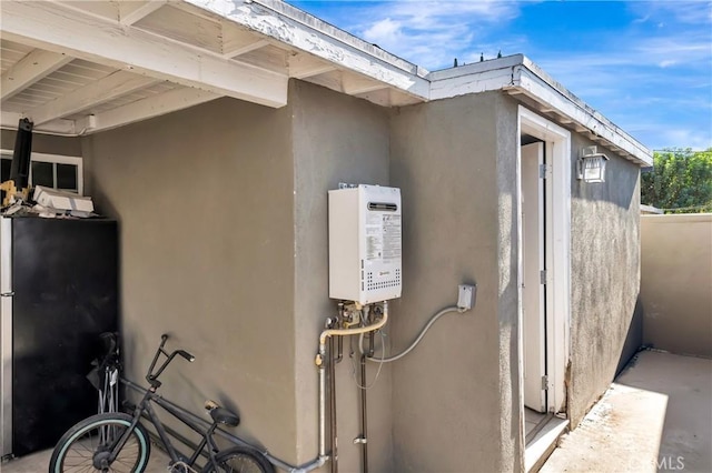 view of home's exterior with water heater and stucco siding