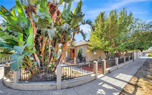 obstructed view of property featuring a fenced front yard and stucco siding