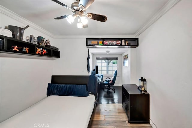 bedroom featuring baseboards, ceiling fan, wood finished floors, and crown molding