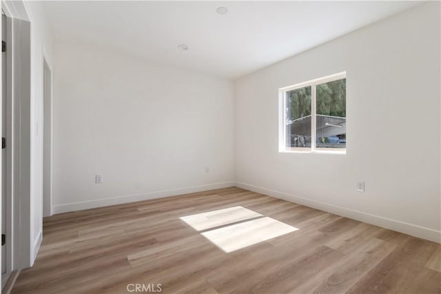 empty room with light wood-style floors and baseboards