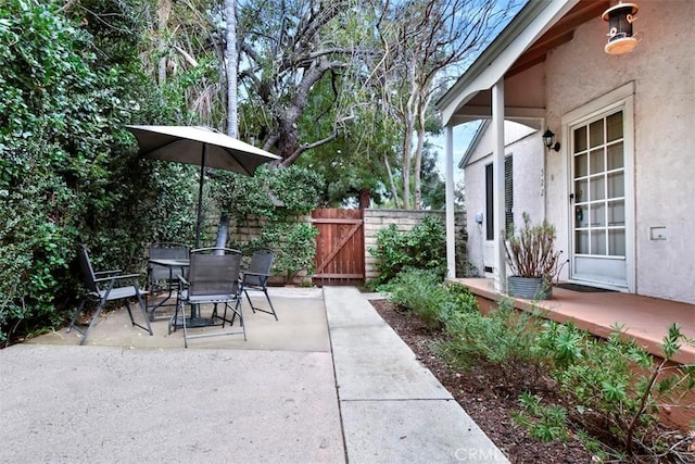 view of patio featuring a gate, outdoor dining space, and fence