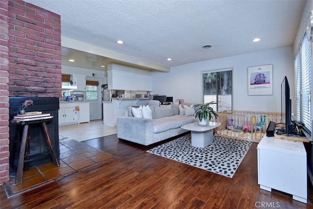 living area featuring a wealth of natural light, a textured ceiling, hardwood / wood-style floors, and recessed lighting