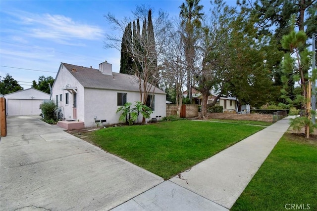 exterior space with fence, stucco siding, a chimney, a yard, and an outdoor structure