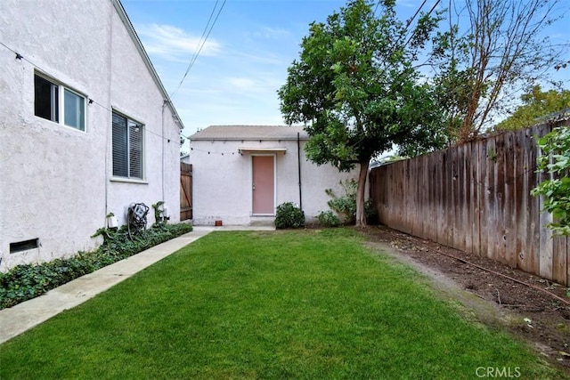 view of yard with an outdoor structure and a fenced backyard