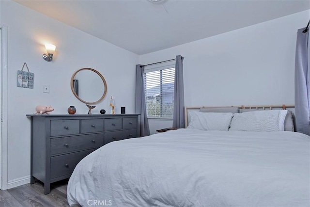 bedroom with wood finished floors and baseboards