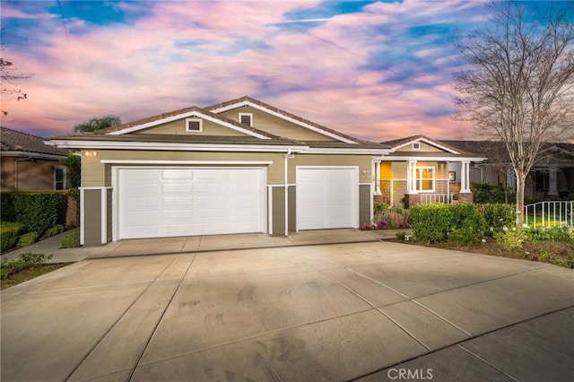 view of front of home featuring a garage, concrete driveway, and a porch