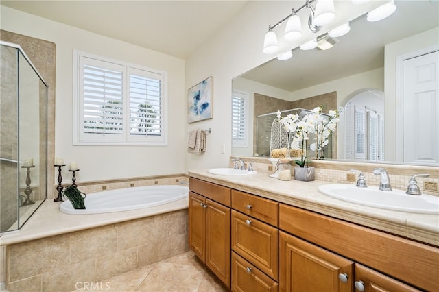 full bath with a stall shower, a garden tub, a sink, and tile patterned floors