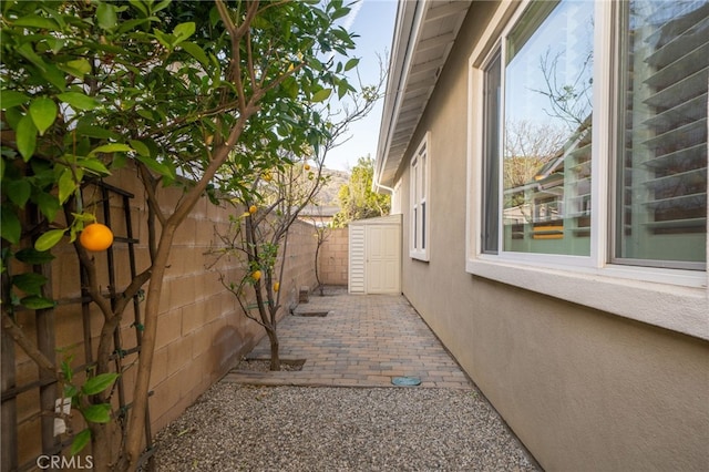 view of side of home featuring a fenced backyard, a patio, and stucco siding