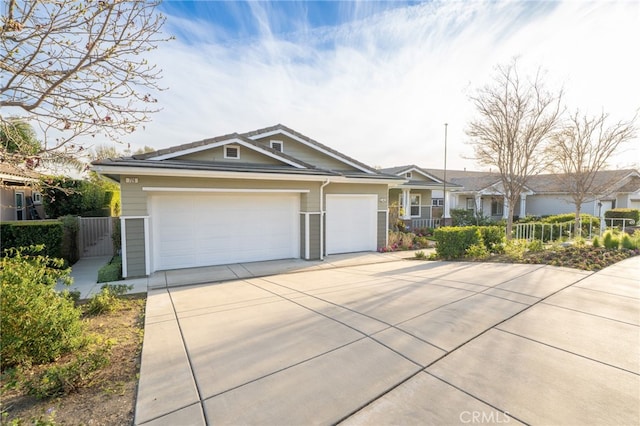 ranch-style house featuring a garage, fence, and concrete driveway