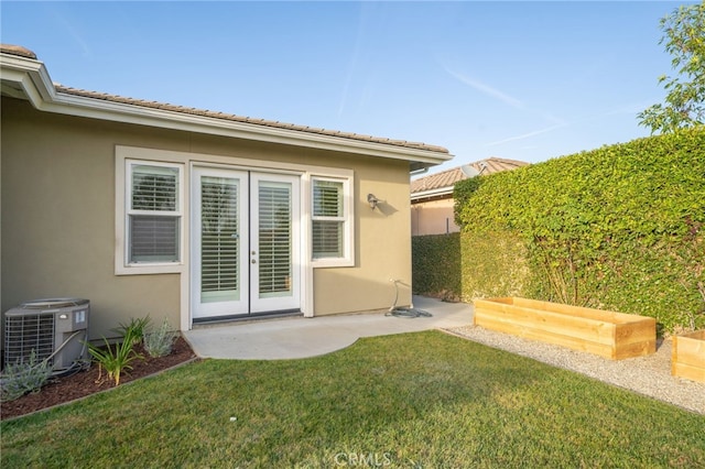 back of house featuring a patio, central air condition unit, french doors, a lawn, and stucco siding