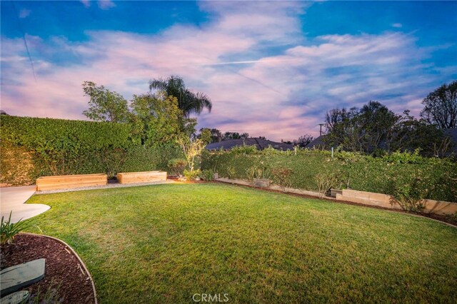 yard at dusk featuring a vegetable garden