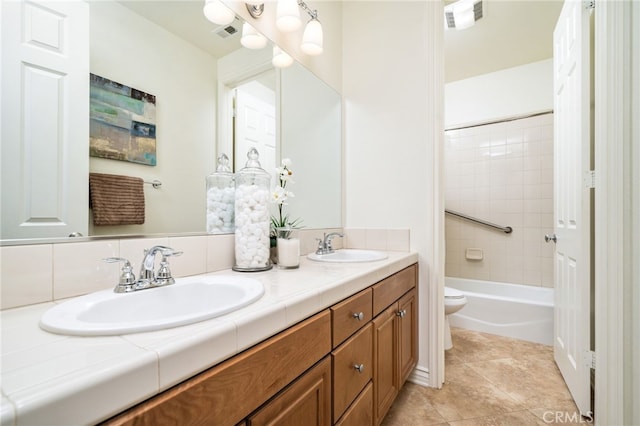 bathroom featuring toilet, a sink, and visible vents