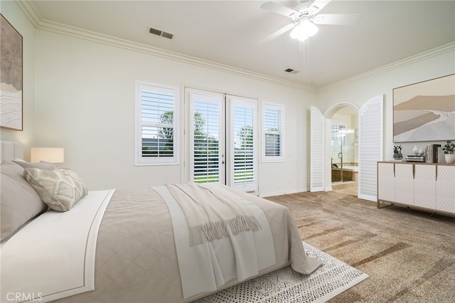 carpeted bedroom featuring arched walkways, ornamental molding, visible vents, and baseboards