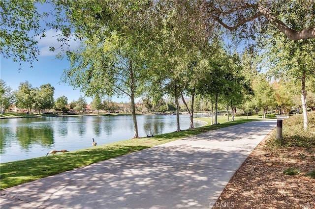 view of community with a lawn and a water view