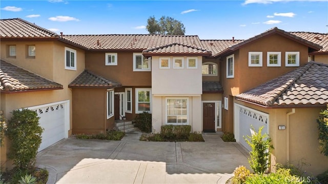 view of front of house with an attached garage, concrete driveway, and stucco siding