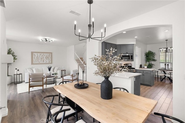 dining space featuring visible vents, stairway, wood finished floors, a chandelier, and recessed lighting