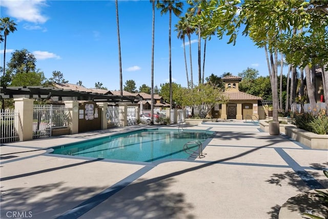 pool featuring fence and a patio