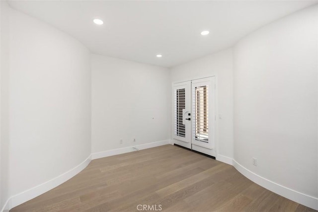 unfurnished room featuring light wood-type flooring, baseboards, and recessed lighting