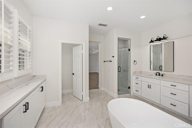 bathroom featuring marble finish floor, visible vents, a freestanding bath, a stall shower, and vanity