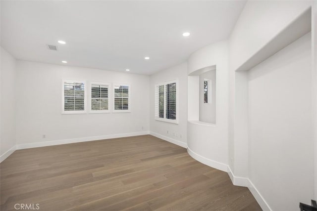 unfurnished room featuring recessed lighting, visible vents, baseboards, and wood finished floors