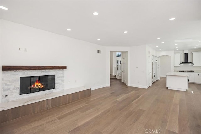 unfurnished living room with light wood-style floors, a fireplace, visible vents, and recessed lighting