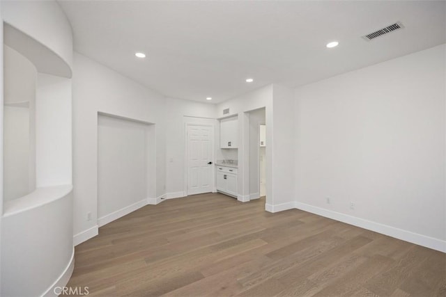 unfurnished room featuring light wood-type flooring, visible vents, and recessed lighting