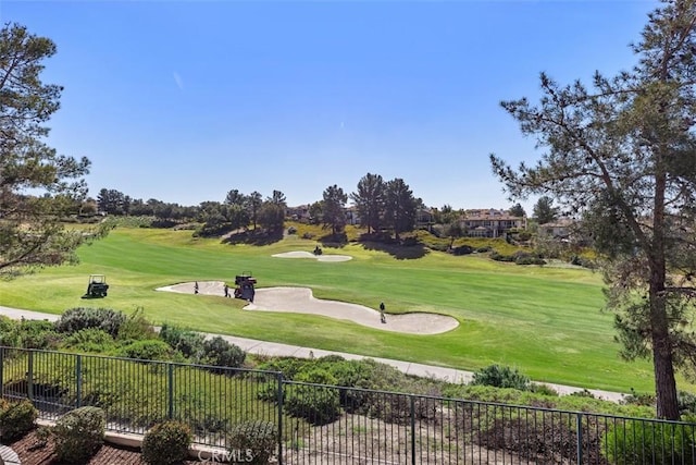 surrounding community with a yard, golf course view, and fence