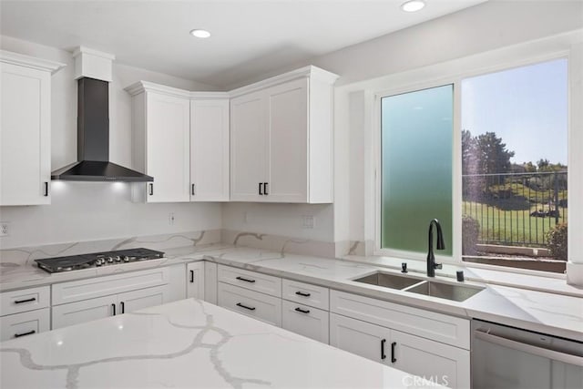 kitchen with white cabinets, wall chimney exhaust hood, stainless steel appliances, a sink, and recessed lighting