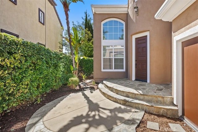 view of exterior entry with stucco siding