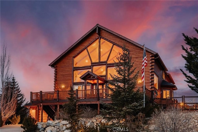 487 Fallen Leaf Rd, Big Bear Lake, CA 92315 - back of house at dusk with stairway, log siding, and a wooden deck