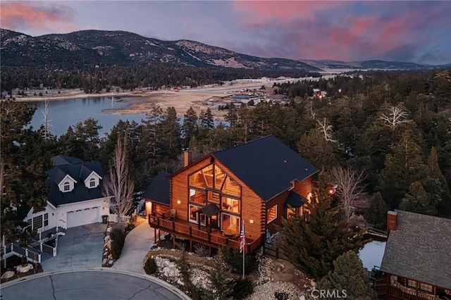 birds eye view of property with a forest view and a water and mountain view