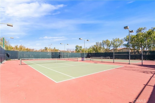 view of tennis court with fence and community basketball court