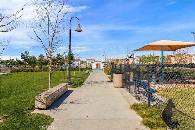 surrounding community featuring a lawn, fence, and a residential view