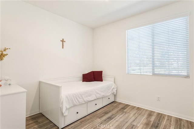 bedroom featuring baseboards and wood finished floors