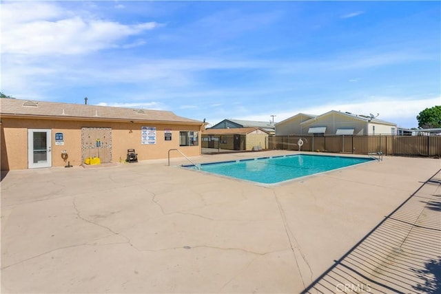 community pool with fence and a patio area