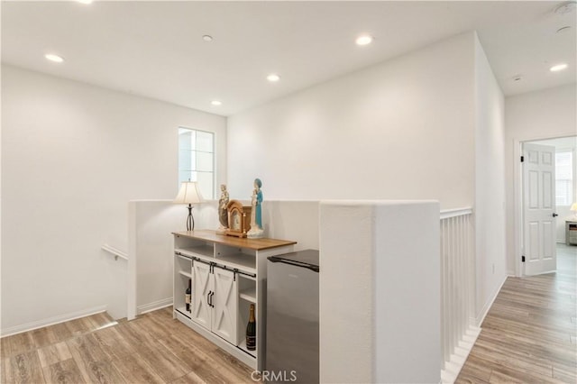 bar featuring light wood-style floors, recessed lighting, and freestanding refrigerator