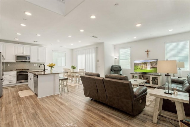 living area with recessed lighting and light wood finished floors