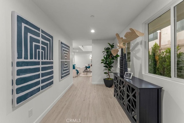 hall featuring recessed lighting, light wood-style flooring, and baseboards