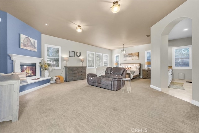 living room with plenty of natural light, carpet, and a glass covered fireplace