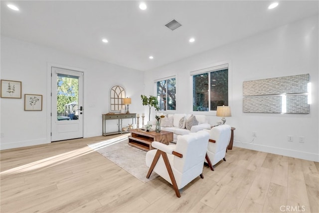 living room featuring a wealth of natural light, visible vents, light wood finished floors, and recessed lighting